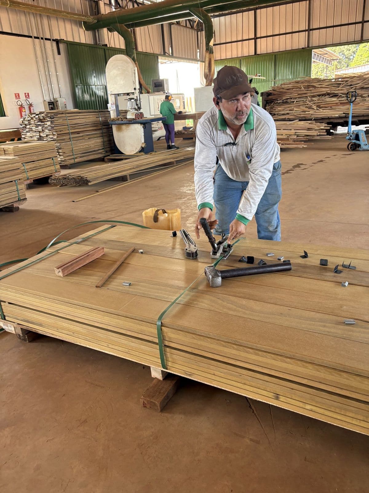 Inspector de Marine Box clasificando tablas de madera dura de exportación en el patio de un productor asociado